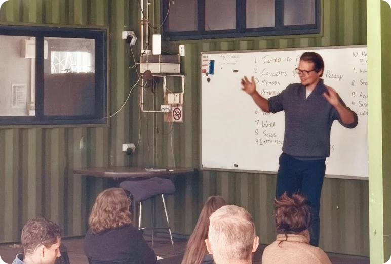 A student presenting to a class in front of a whiteboard