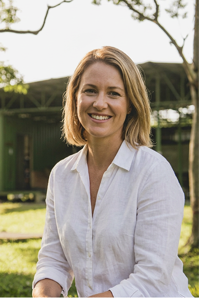 Smiling woman in a white linen shirt in a garden